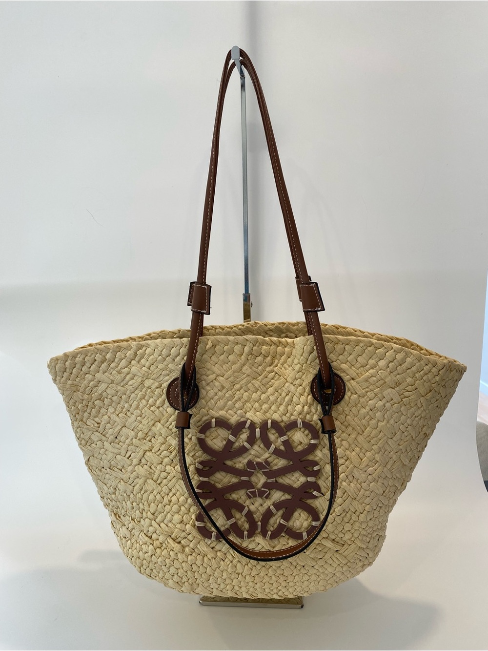Woven Straw Tote with Brown Leather Trim and Decorative Accent